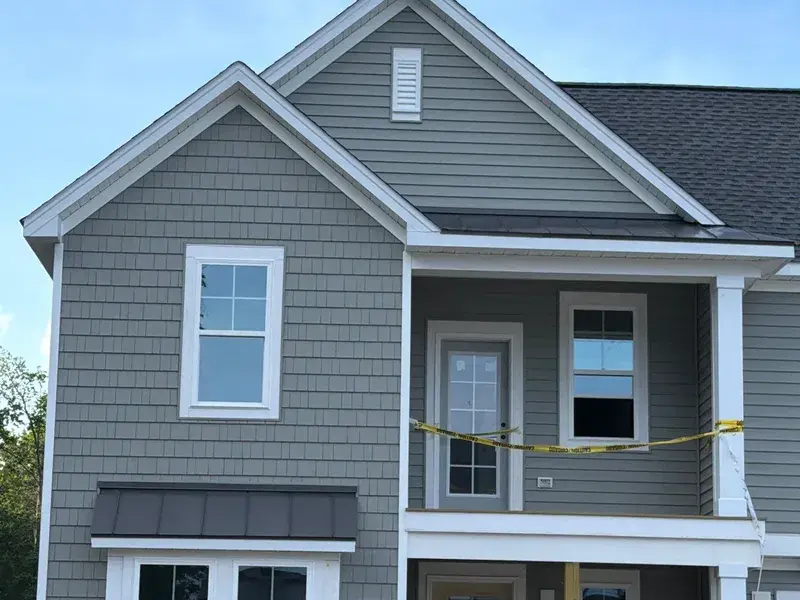 Charcoal gray standing seam metal roof accent on new construction home in Kennebec NC