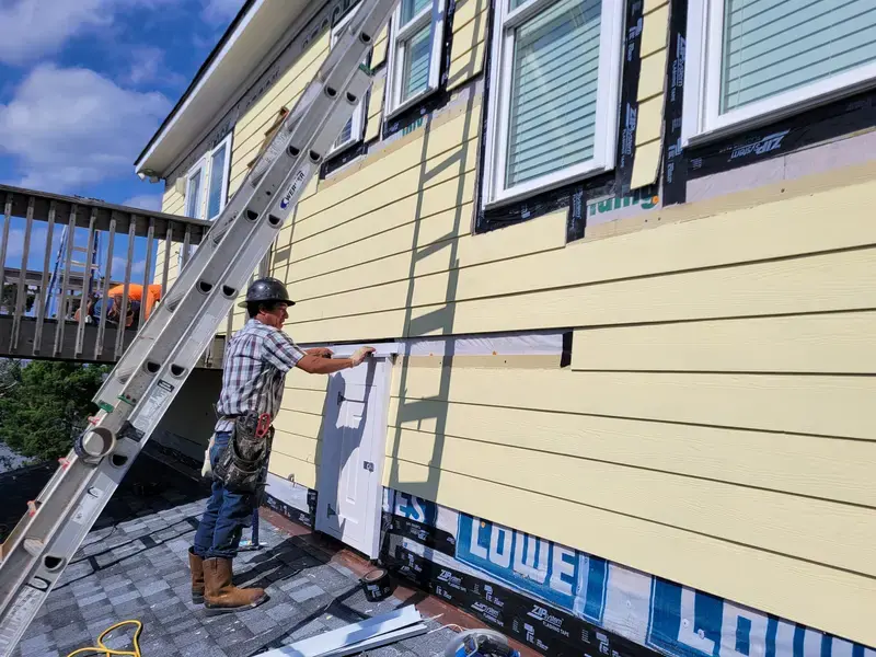 Siding crew installing boards on North Carolina home