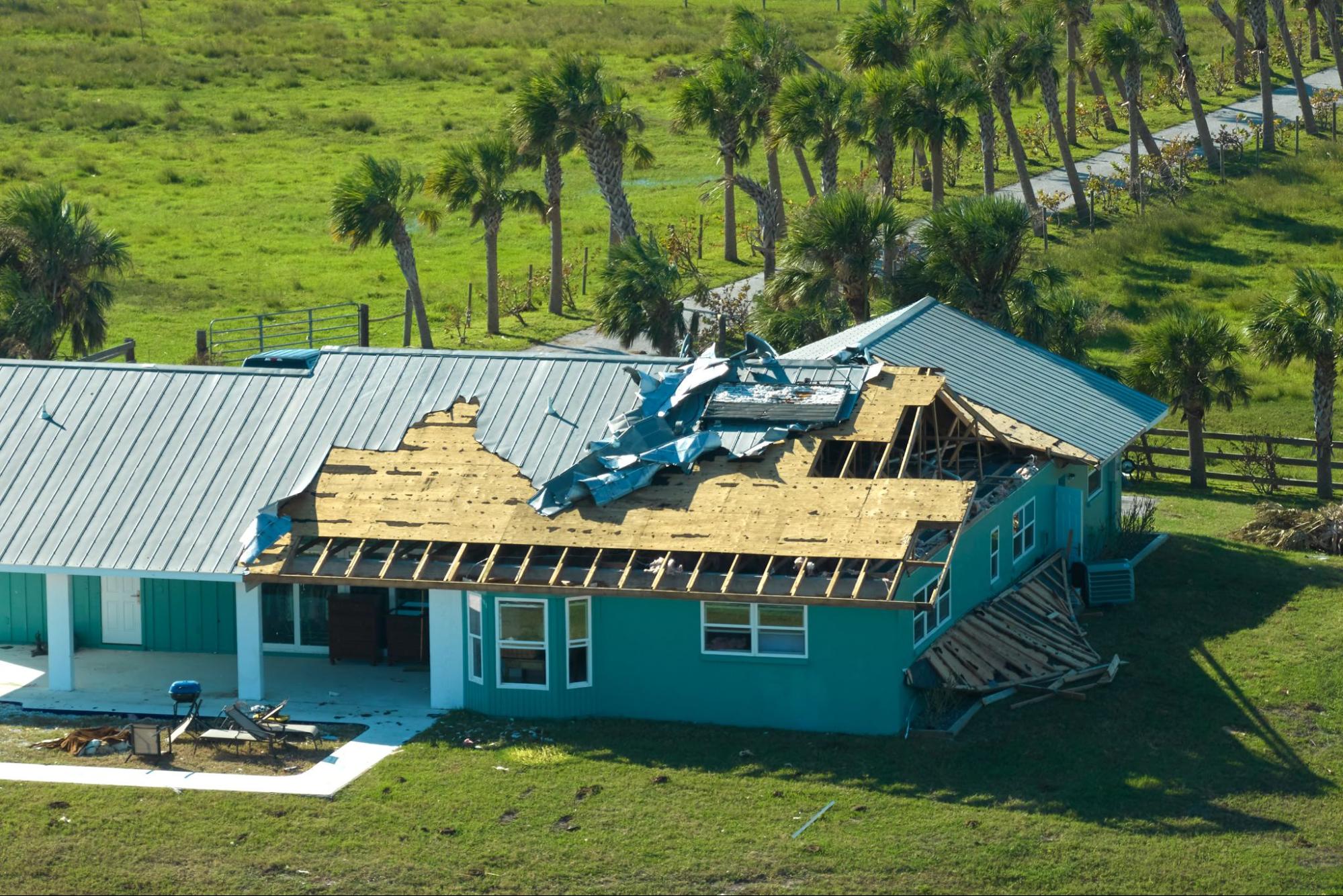 Hurricane-damaged house roof in a suburban Florida neighborhood