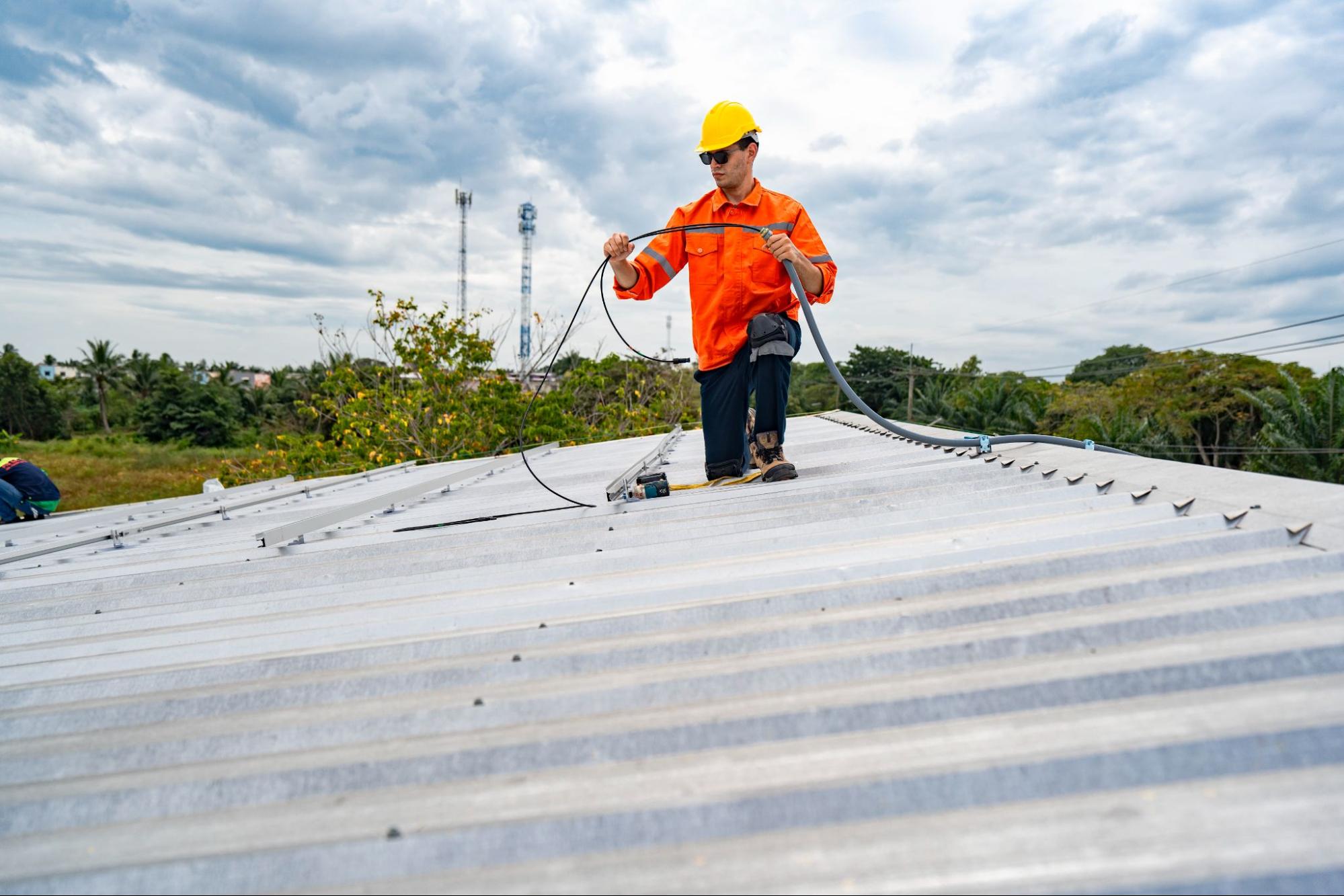 Roofer inspecting a residential roof as part of routine maintenance in a roof replacement schedule