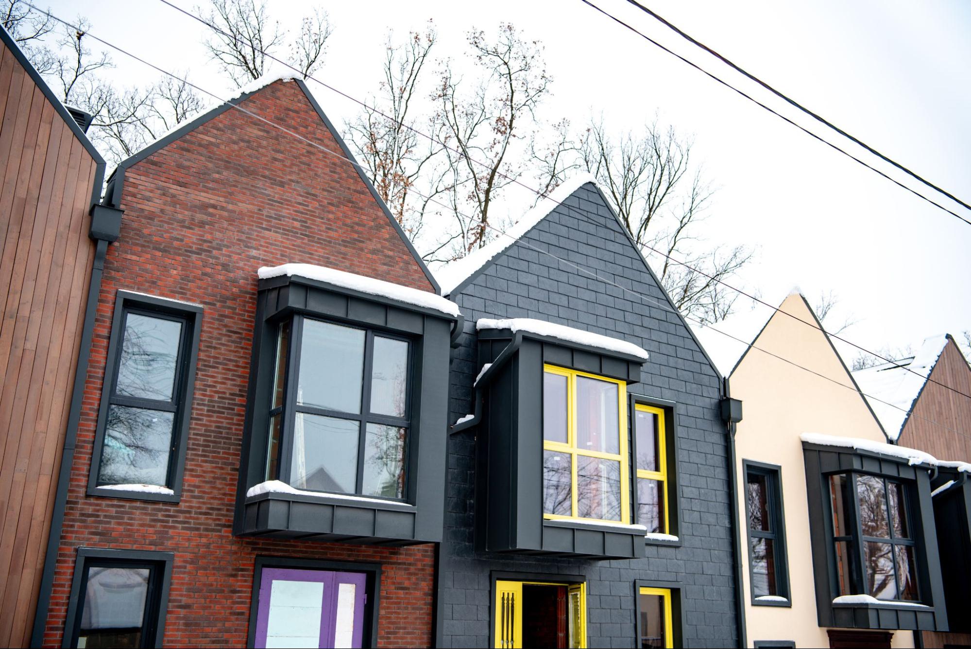 Modern homes with fiber cement siding and snow-covered roofs in winter.