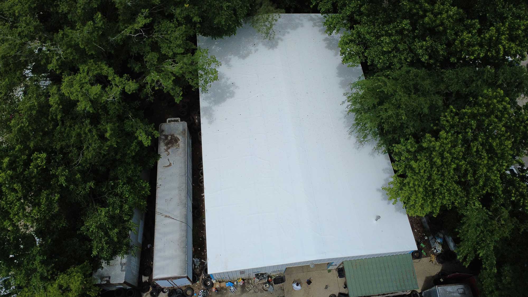 Aerial perspective of a white building framed by trees, highlighting the building's integration into its environment