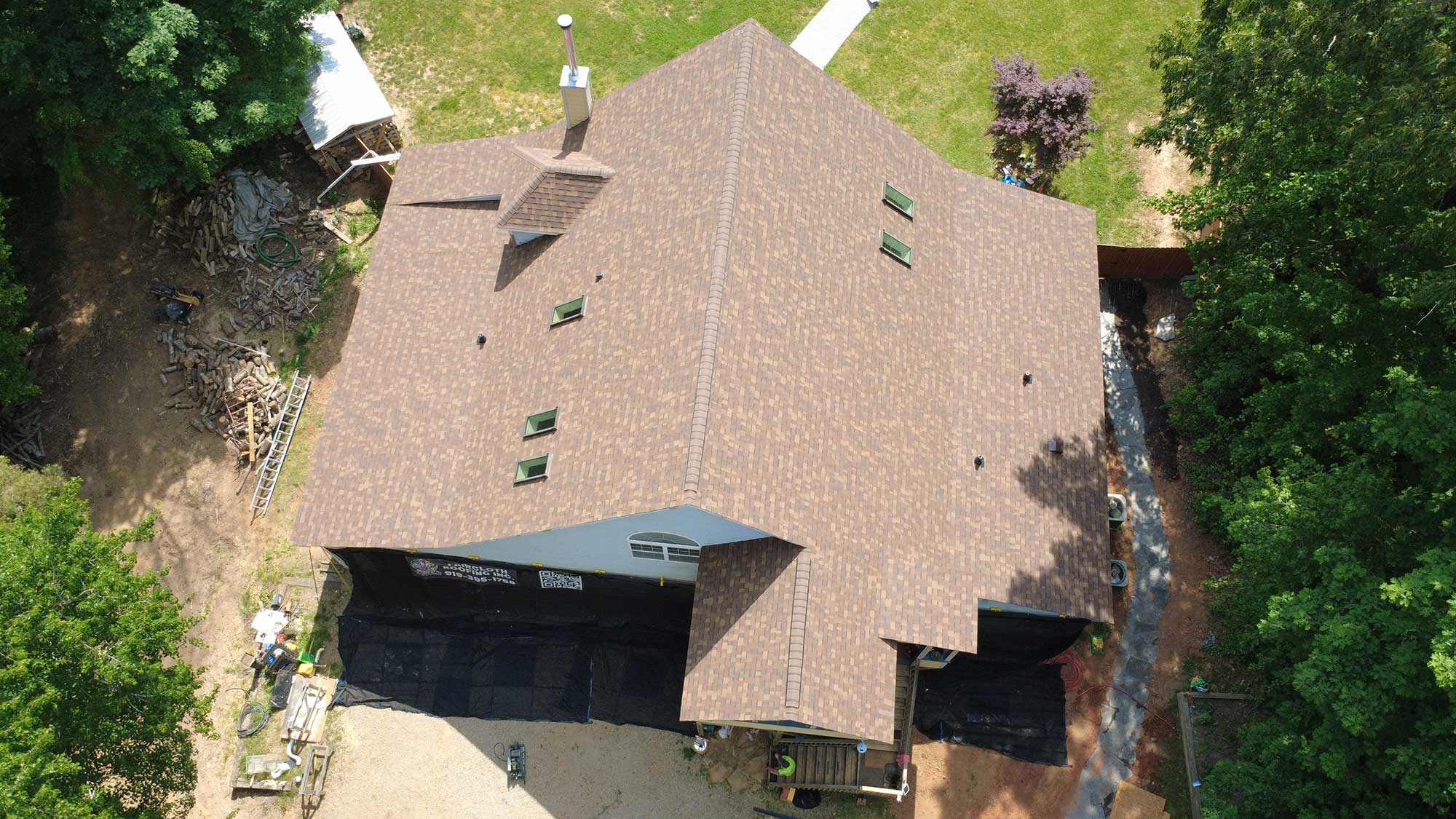 Aerial view of a house showcasing its roof and surrounding landscape.