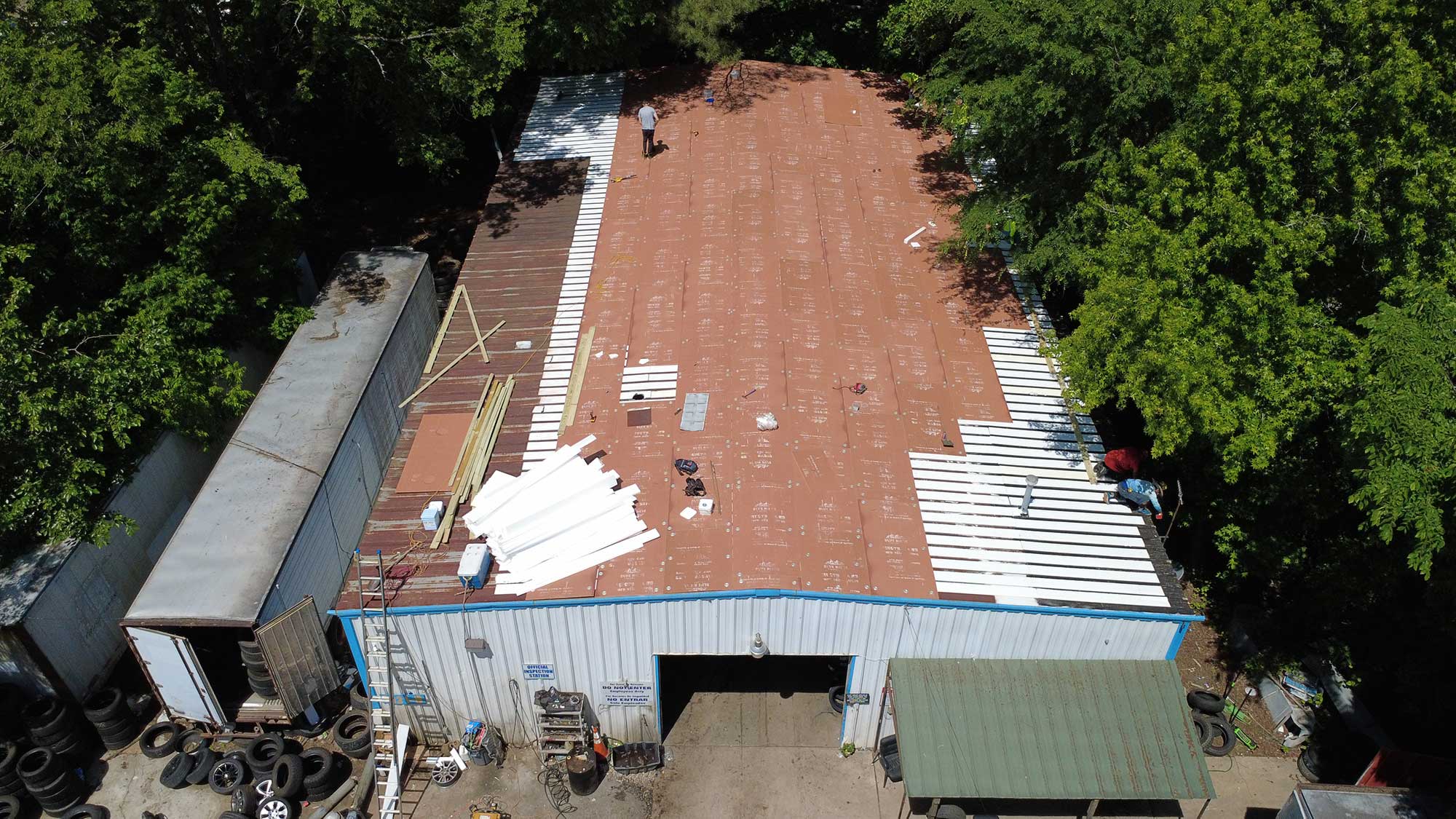 Bird's-eye view of a building featuring a roof, capturing its structure and the surrounding landscape.