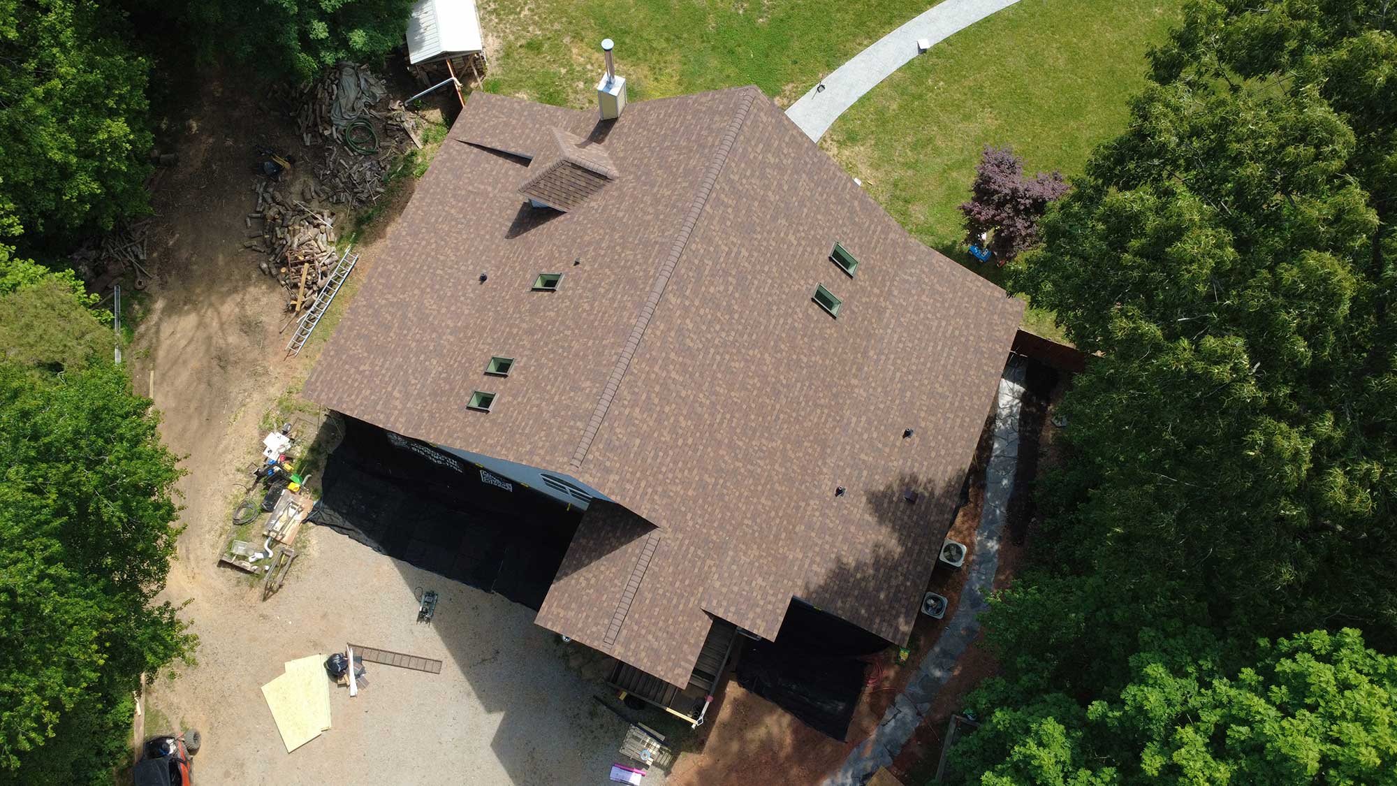 Overhead view of a house with a prominent roof and landscaped surroundings.