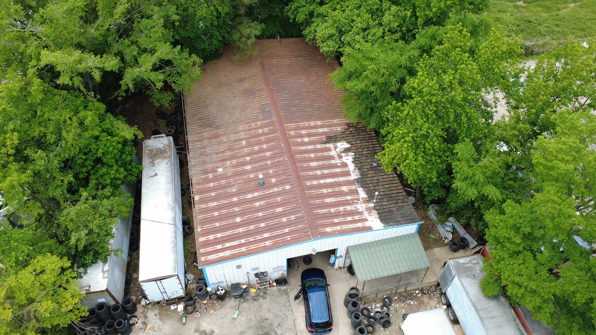 Top-down view of a building with a roof, displaying its design and the surrounding environment from above.