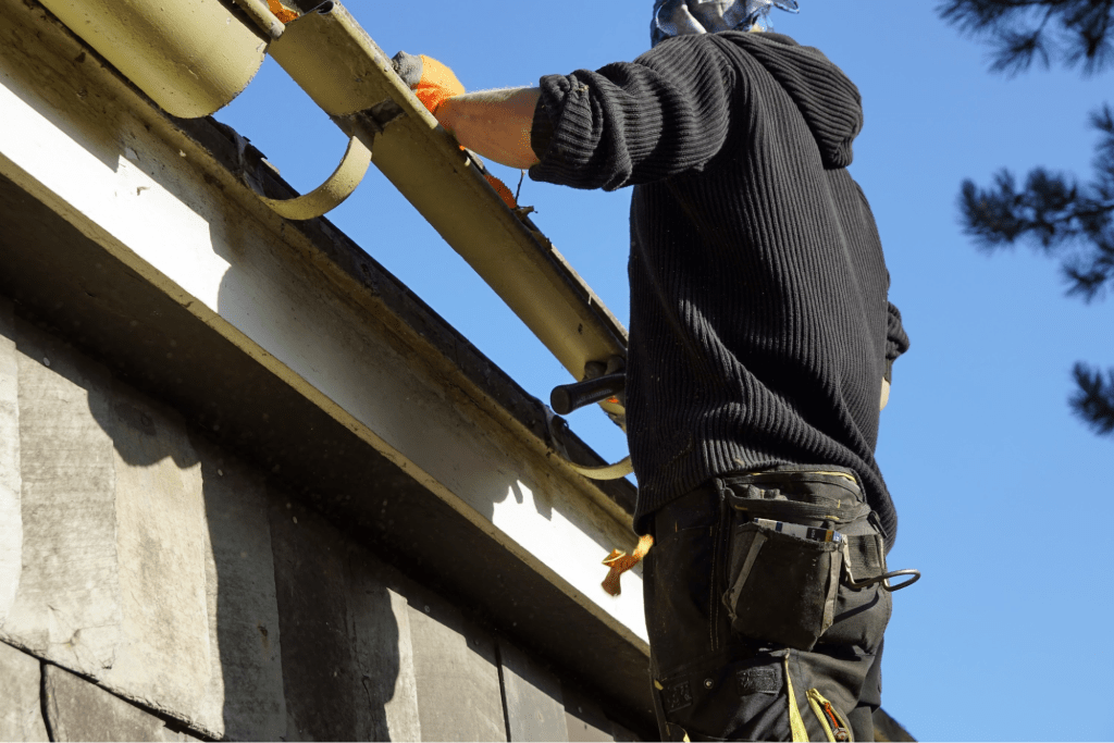 A contractor installing a rain gutter.