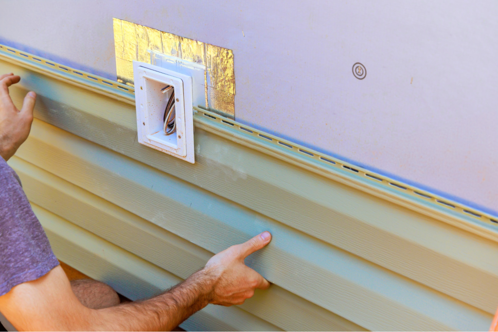A man installing vinyl siding.