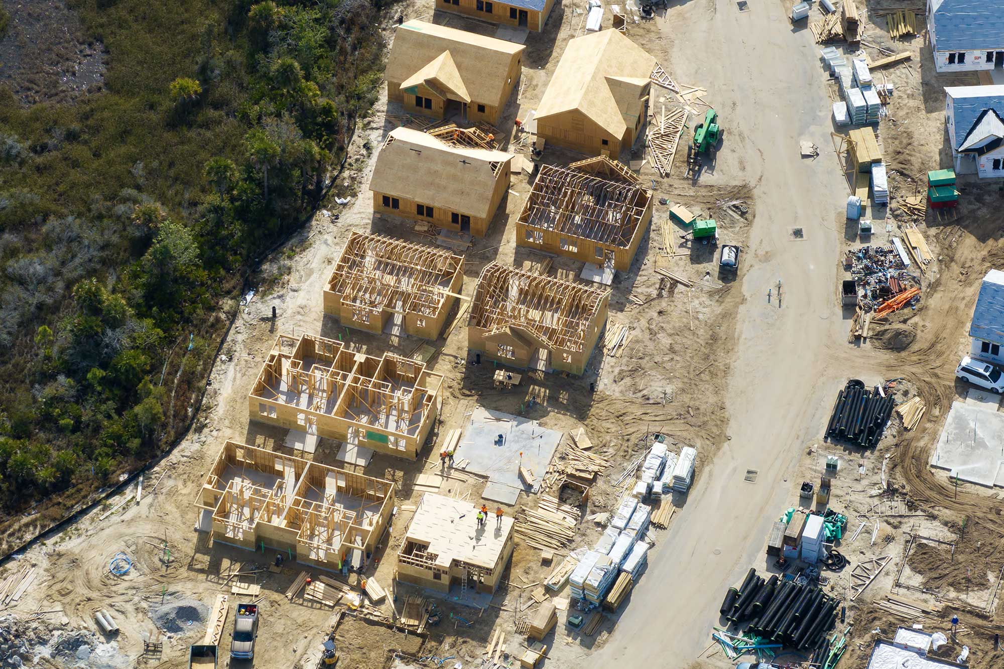 Aerial view of a residential construction site with unfinished wooden houses.